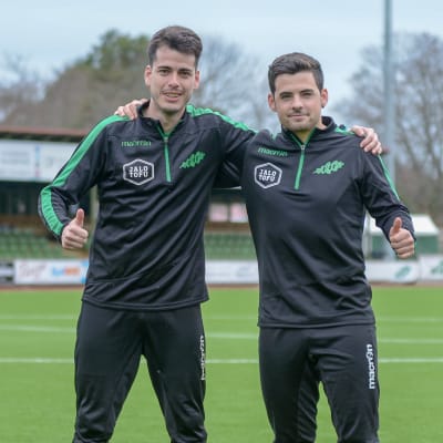Två fotbollstränare står bredvid varandra.