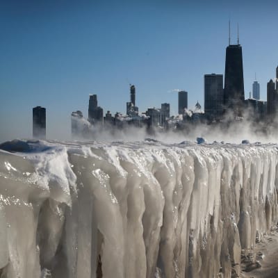 Chicagos skyline med is i förgrunden.