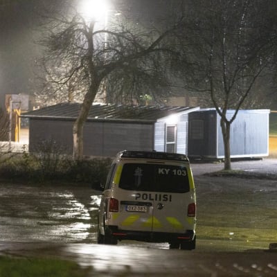 Poliisiauto ajaa hämärässä. Kuvattu takaa.