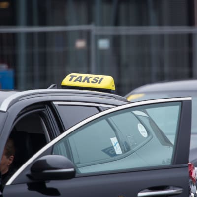 Två taxibilar står och väntar på nya kunder.