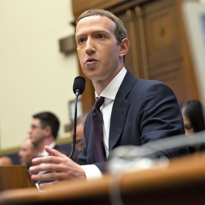 Mark Zuckerberg istuu pöydän takana ja puhuu mikrofoniin.