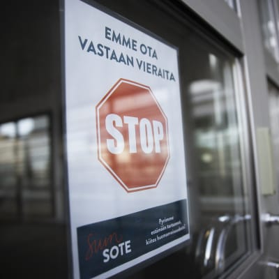 Vieraat kieltävä kyltti Pohjois-Karjalan keskussairaalan ulko-ovissa.