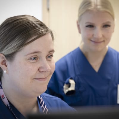 Digihoitajat Lotta Nokelainen ja Miina Kauppinen katselevat tietokoneen ruutua Savonlinnan terveyskeskuksen hoitohuoneessa.