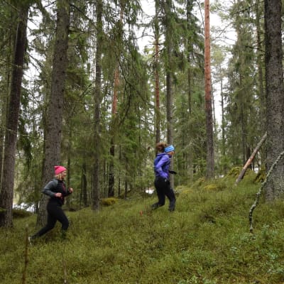 Elin Skagersten-Ström och Ida Kronholm springer i skogen.