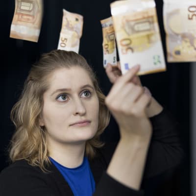 Liisa Salonen poimii viidenkymmenen euron seteteleitä ilmasta.