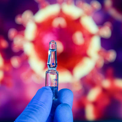 Ett foto på ett potentiellt coronavaccin, med en illustration på coronavirus i bakgrunden.