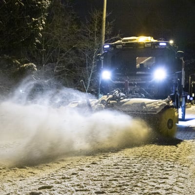Kuorma-auton lakaisuharja lakaisee lumista tienpintaa.