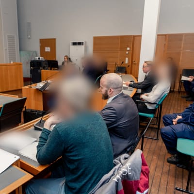 Keski-Suomen käräjäoikeuden istuntosali. Salissa istuu syytettyjä ja muuta käräjäoikeuden henkilökuntaa.
