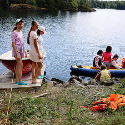 Ukrainalaislapset katselevat kun toiset lapset lähtevät kanootilla vesille.