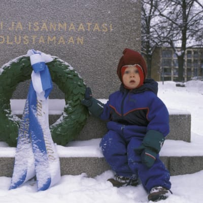 Ett litet barn vid hjältegraven på självständighetsdagen 1997.