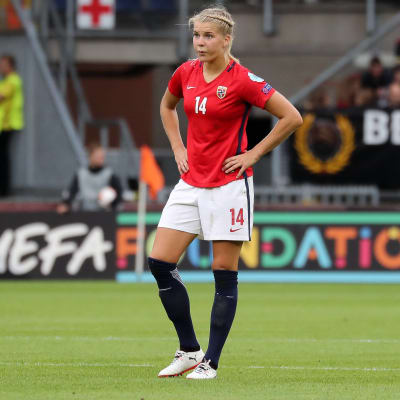 Ada Hegerberg står på en fotbollsplan.