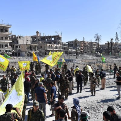 Medlemmar av syriska demokratiska styrkorna SDF uppbackade av amerikanska styrkor  samlas vid ett torg i Raqqa 17.10.2017.