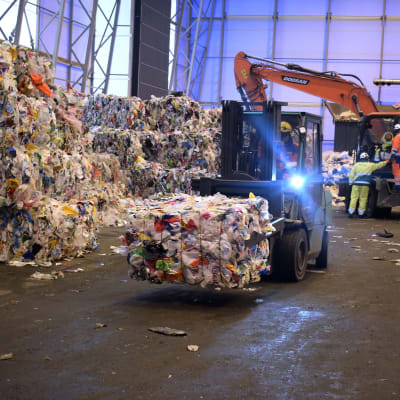 Kuva Fortumin muovinjalostamosta, trukki kuljettaa muovikierrätykseen meneviä kotitalouksista kerättyjä muovijätepaaleja