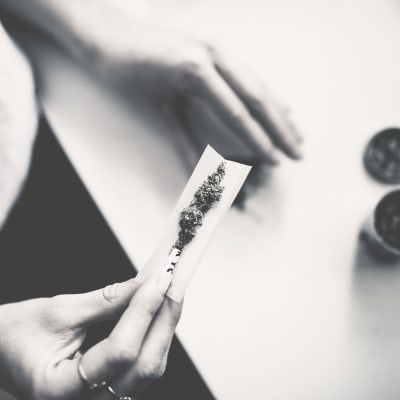 Någon rullar en cannabiscigarette.