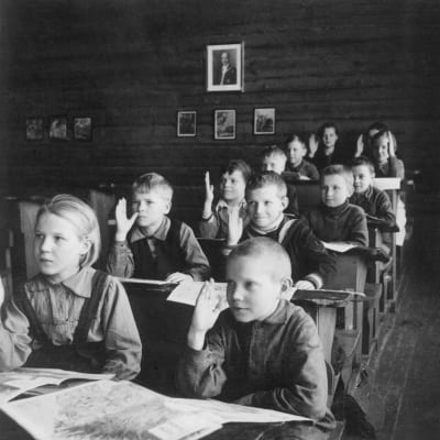 Svartvit bild av skolelever som sitter i ett klassrum