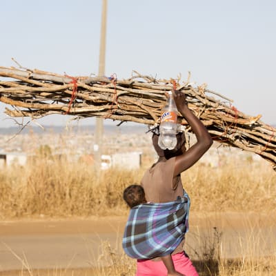 Nainen kantaa polttopuita Hararen kaupungissa Zimbabwessa.