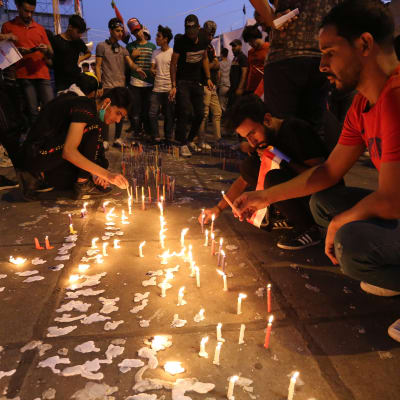 Regeringskritiska demonstranter i Bagdad tänder ljus till till minnet av de nära 300 demonstranter som har dödats