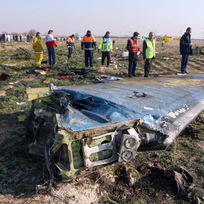 Iranska räddningsarbetare intill vrakdelar, ett 30-tal kilometer utanför Teheran, den 8 januari. 