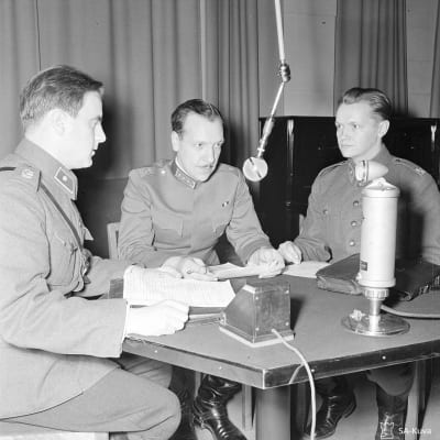 Reservin vänrikki Kalle Lehmus (oik.), kapteeni Reino "Palle Palmroth ja reservin vänrikki J.O. Tallqvist valmistautuvat radiolähetykseen lokakuussa 1939