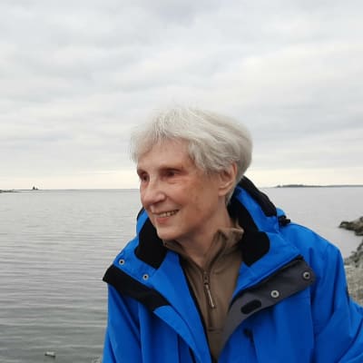Rosemary Chrimm seisoo Raippaluodossa meren äärellä
