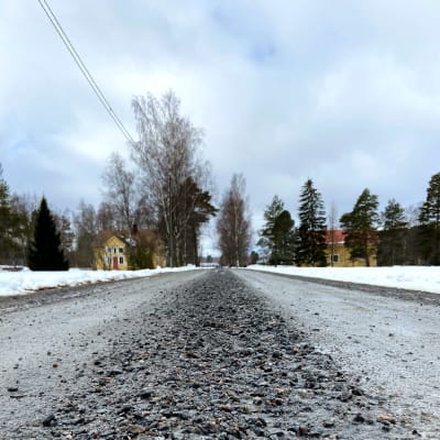 Grusväg som leder till ett gult hus.