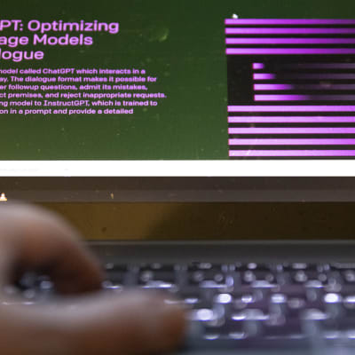 En hand vid ett tangentbord. På skärmen står det Chat GPT.
