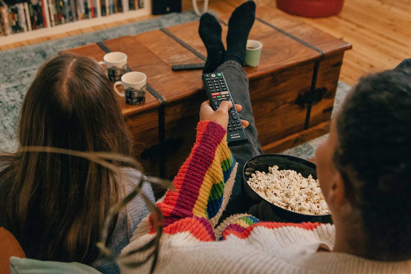 Lapset katsovat televisiota, kaukosäädin kädessä