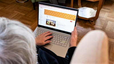 En äldre person använder en bärbar dator.