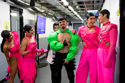 Käärijä iklädd grönt, och hans dansare iklädda rosa, står bakom scenen inför en av de första övningarna inför Eurovision Song Contest.