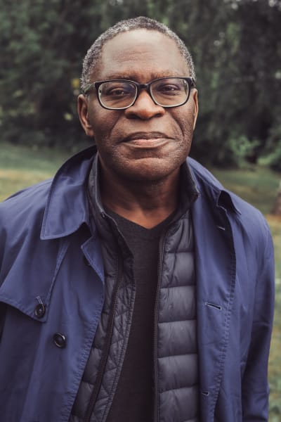 Säveltäjä Charles Uzor katsoo suoraan kameraan vihreässä puistoympäristössä.