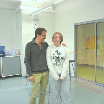 Rektor Antti Jyrkkänen och eleven Jeanette står i skolans bibliotek.