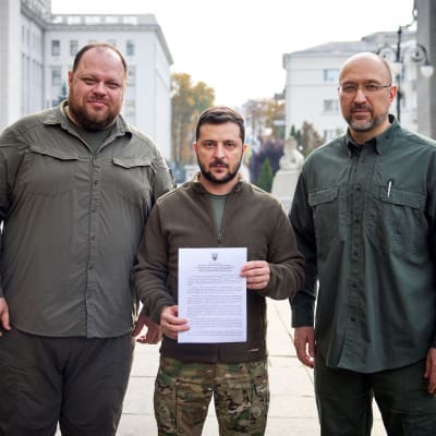 Ruslan Stefanchuk, Volodymyr Zelenskyj och Denys Shmyhal visar upp Natoansökan med sina underskrifter.