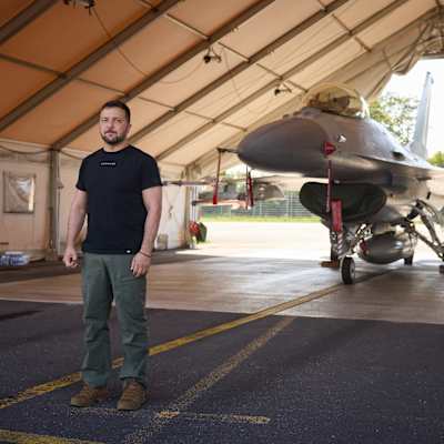 Ukrainas president Volodymyr Zelenskyj står framför ett F-16 flyg.