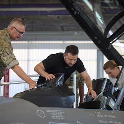 En militär, Zelenskyj, och Danmarks statsminister Frederiksen inspekterar kockpit på en F-16