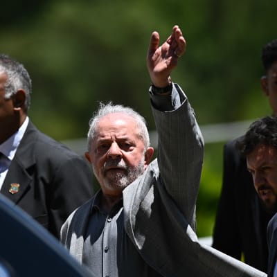 Lula da Silva heiluttaa kättään noustessaan autoon. Hän on juuri kertonut ministerinimityksistään.