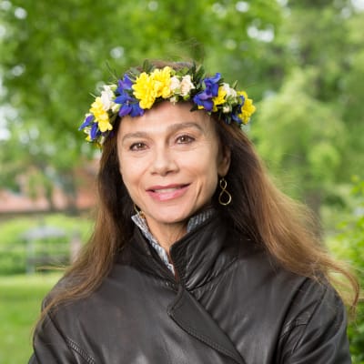 Skådespelare Lena Olin med blomsterkrans i håret.