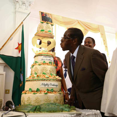 Zimbabwes president Robert Mugabe blåser ut ljusen på en födelsedagstårta den 22 februari i Harare.