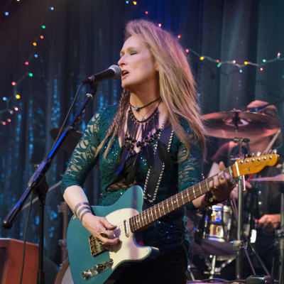 Meryl Streep rockar loss med en gitarr på scenen
