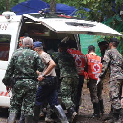 Räddningsarbetare lyfter in en av de räddade pojkarna i en ambulans