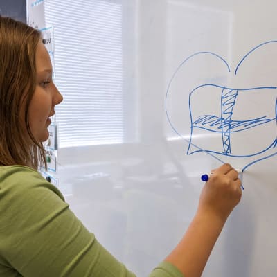 Katya piirsi valkotaululle suomenlipun sydämen sisälle.