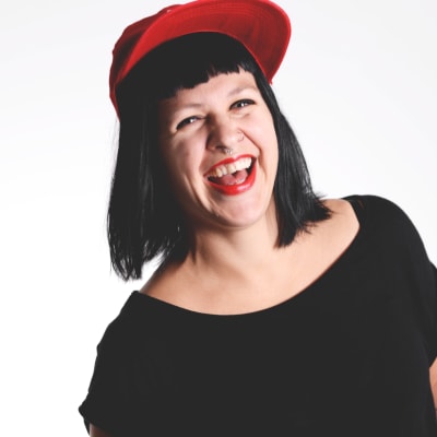 Catariina Salo: Tjej med svart hår och pannlugg, som har en röd keps och en svart t-shirt på sig.