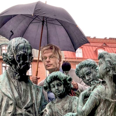 Skådespelare Oskar Pöysti bakom en Topeliusstaty