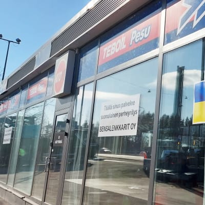 Ukrainska flaggan på fönstret till en Teboilstation.