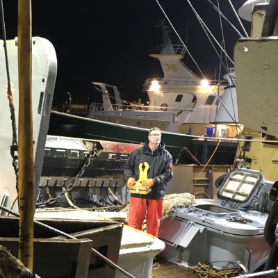 Fiskaren Cor Vonk övervakar avlastandet av fångsten ombord på däck. I handen har han en apparat för fjärrstyrningen av en vinsch. 