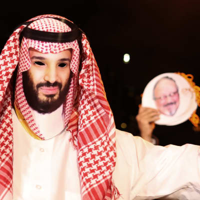 En demonstrant iklädd en mask som föreställer kronprins Mohammed. Bild på Khashoggi i bakgrunden. Denhär demonstrationen hölls utanför Saudiarabiens konsulat i Istanbul den 25 oktober. 