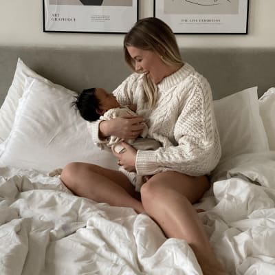 Linda Juhola istuu vauvan kanssa sängyssä.