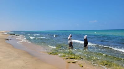 Ujuni Ahmed ja Elina Hirvonen Somalimaan Berberassa rannalla, kahlaavat rantavedessä.