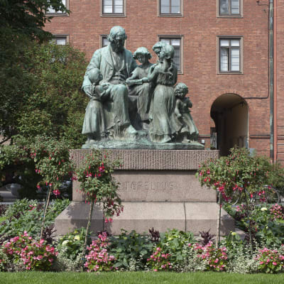 Staty föreställande Zacharias Topelius omgiven av barn.
