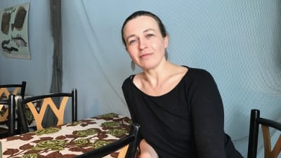 Camilla Snickars i svart tröja vid ett bord.