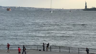 Utsikt över södra Manhattan, joggare på stranden